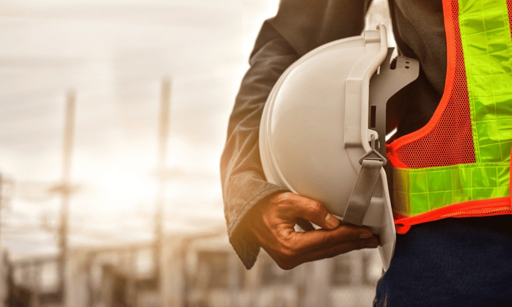 construction industry scheme deductions- man in a high vis jacket holding a hardhat