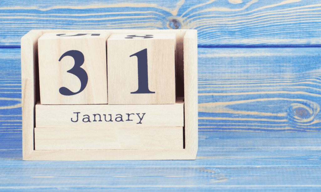 Self assessment tax return deadline: Image shows a wooden calendar block on a blue wooden table - the date on the calendar reads 31 January